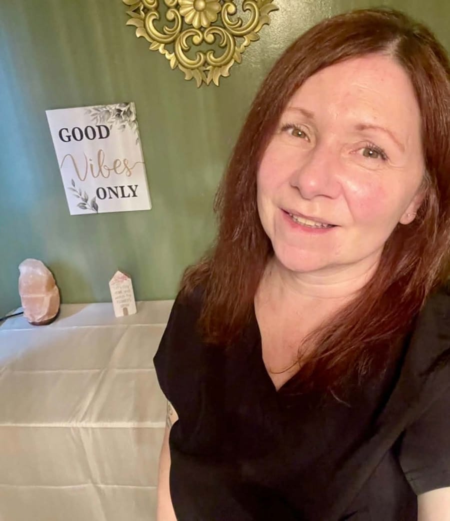 Christine smiling in her sage-green treatment room